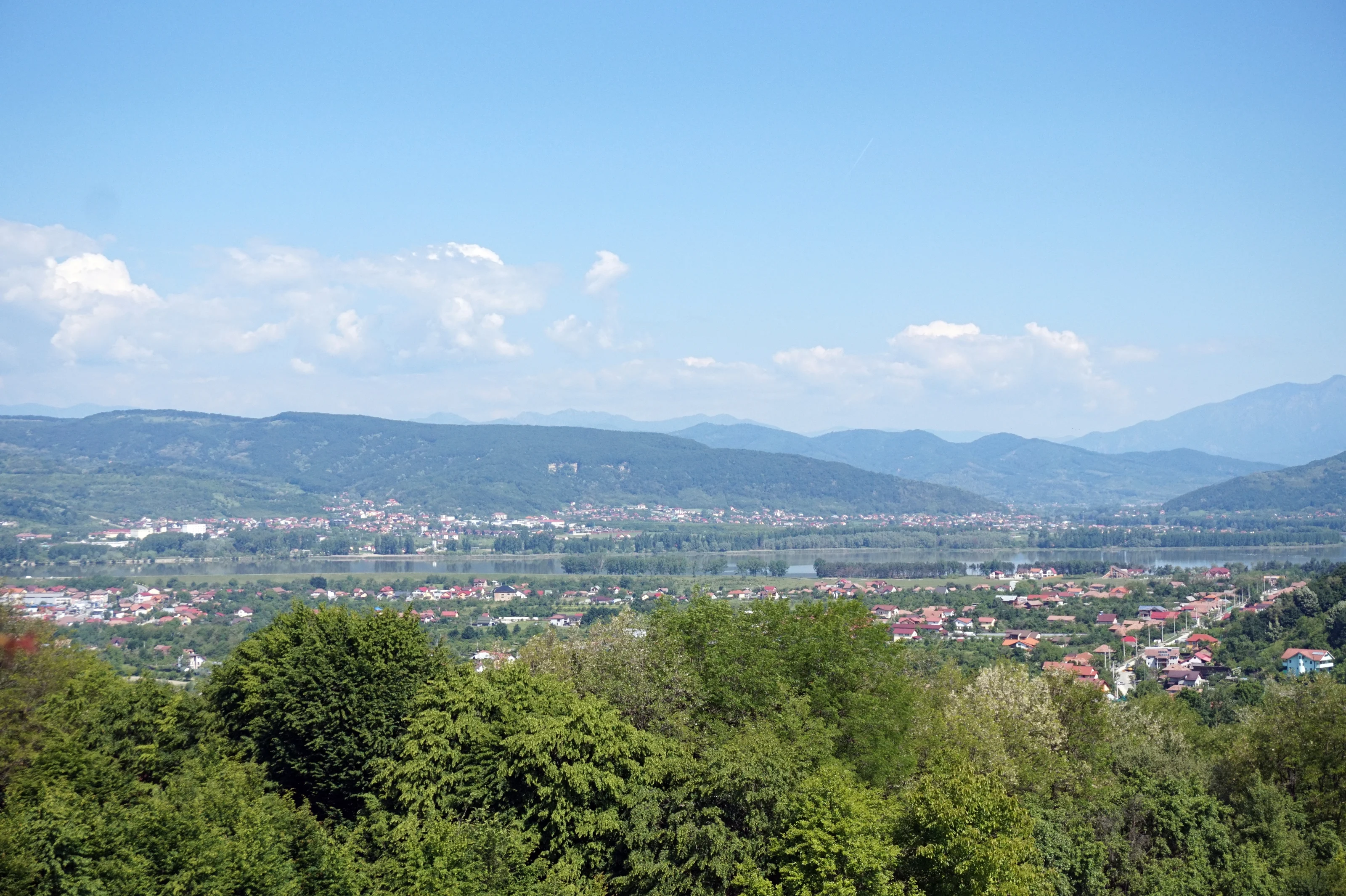 Fotografie reală panoramică din Râmnicu Vâlcea, cu râul Olt și dealurile din jur